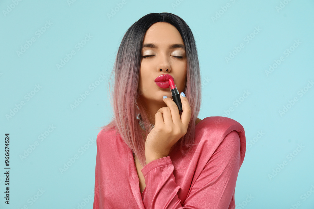 Portrait of beautiful young woman in wig with lipstick on blue background Portrait of beautiful young woman in wig with lipstick on blue background