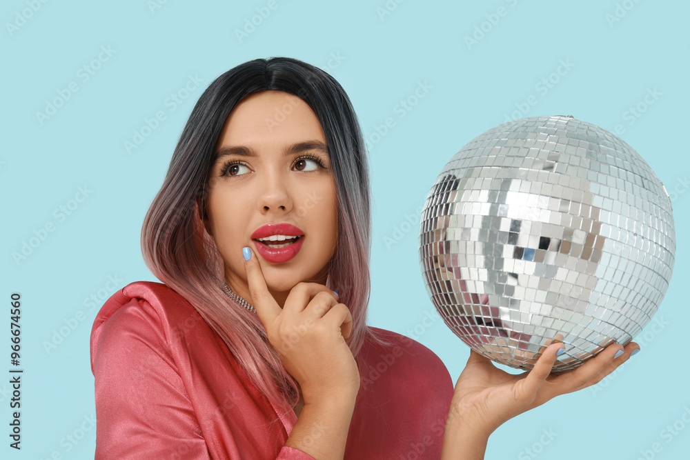 Portrait of pondering young woman in wig with disco ball on blue background Portrait of pondering young woman in wig with disco ball on blue background