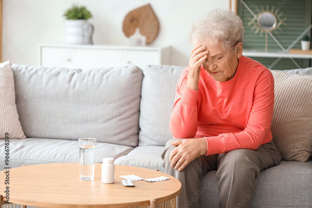 Sick senior woman with pills at home