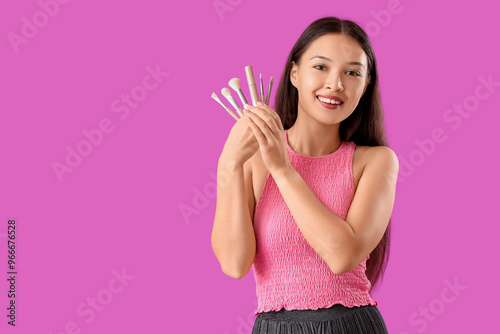 Smiling young asian woman h...