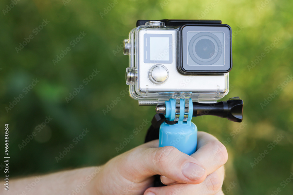Man holding monopod with modern action camera outdoors, closeup Man holding monopod with modern action camera outdoors, closeup