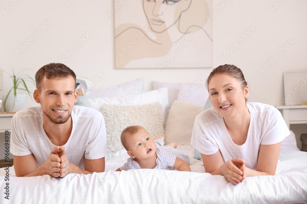 Happy young couple with cute little baby lying on bed at home Happy young couple with cute little baby lying on bed at home