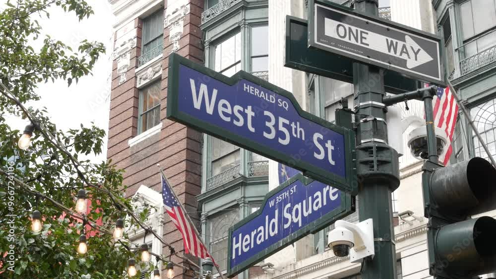 New York City crossroad, Manhattan Broadway street intersection road sign. NYC Midtown district architecture, Herald Square park, 6 Sixth avenue, United States. American flag. One way arrow road sign. New York City crossroad, Manhattan Broadway street intersection road sign. NYC Midtown district architecture, Herald Square park, 6 Sixth avenue, United States. American flag. One way arrow road sign.