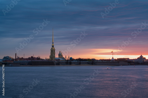 View of the Peter and Paul Fortress and the Neva River against a pink dawn sky with clouds on a sunny spring morning, St. Petersburg, Russia