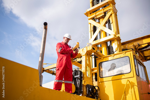 Engineer or worker are standing forklift or truck vehicle are holding detail and appear to be discussing or reviewing documents, likely related to inspect about factory and industry environment. photo