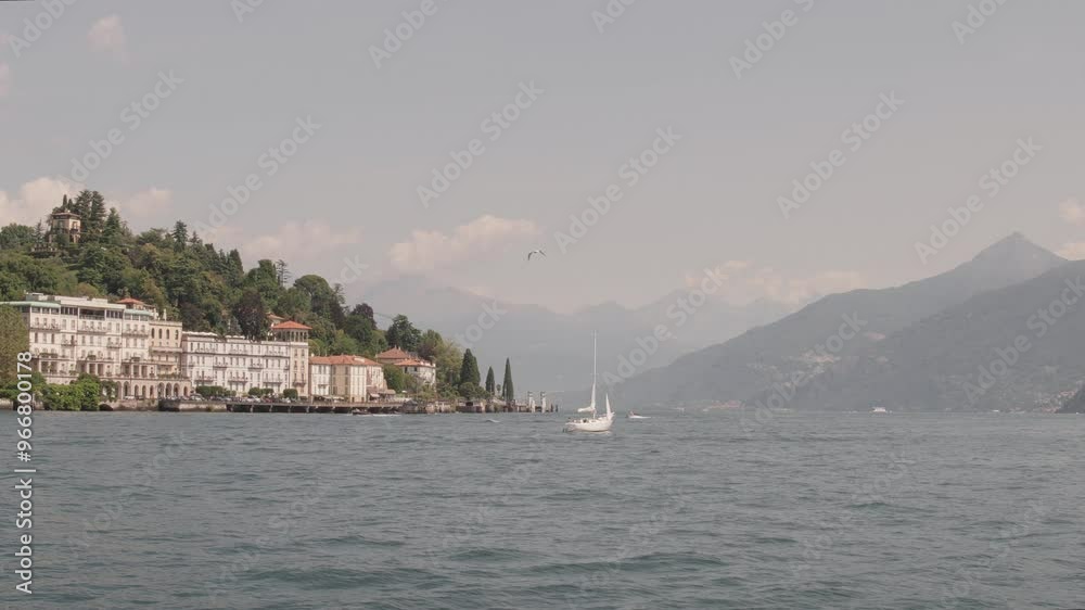 Birds and sailboats move along Lake Como in Italy. Birds and sailboats move along Lake Como in Italy.