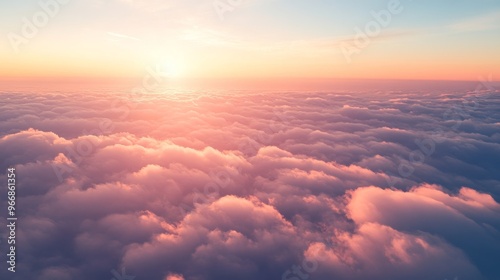 The vibrant colors of pink and orange spread across the sky at sunset as seen from above the clouds, creating a stunning aerial perspective that evokes tranquility