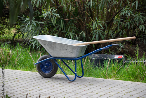 A wheelbarrow is sitting on a brick walkway photo