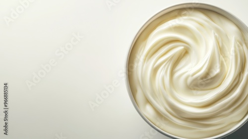 Smooth vanilla yogurt fills a white bowl, its texture swirled elegantly as natural light highlights its creamy surface, creating an inviting culinary scene photo