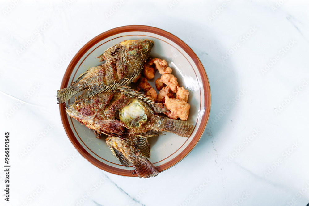 Fried fish served on a white plate. isolated on white background. Fried fish served on a white plate. isolated on white background.