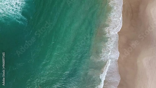 A group of surfers paddling over a large wave at Gold Coast. Concept beauty and peace in sport in wild nature