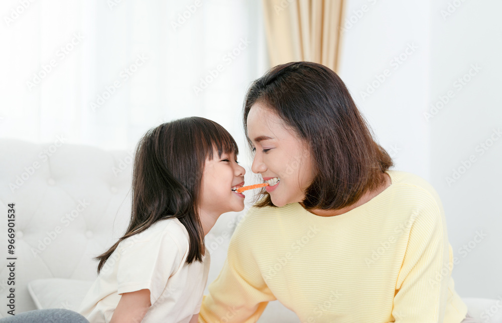 Asian mother enjoying with daughter in living room at home Asian mother enjoying with daughter in living room at home