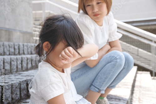 Bild auf Leinwand 泣いている子供と心配する女性。メンタルと体の不調を訴える