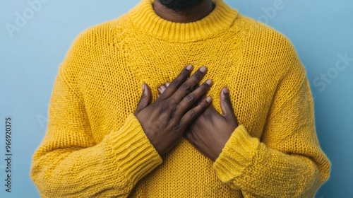Photograph depicting a person in the midst of a debilitating panic attack grasping their chest tightly as they struggle to breathe and cope with the overwhelming surge of anxiety and emotion