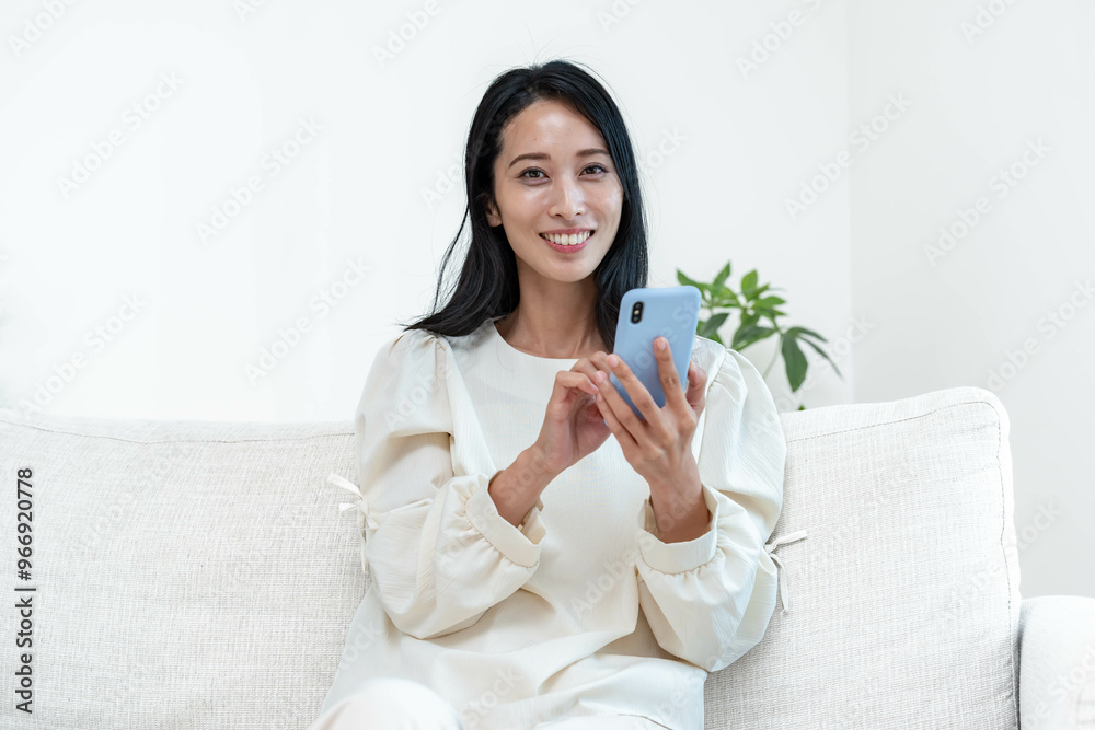 カメラ目線で携帯を持つ日本人の女性 カメラ目線で携帯を持つ日本人の女性
