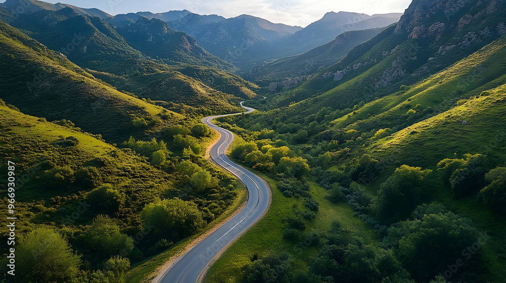 A scenic winding road through lush green hills and mountains under a clear sky. A scenic winding road through lush green hills and mountains under a clear sky.