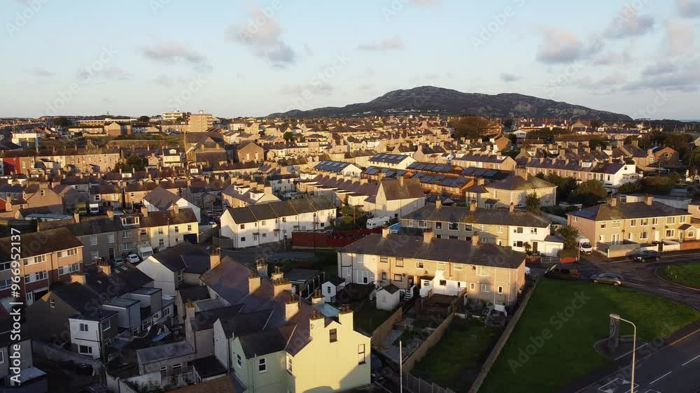 Holyhead island fishing village aerial view circling sunlit homes mountain and townhouse property Holyhead island fishing village aerial view circling sunlit homes mountain and townhouse property