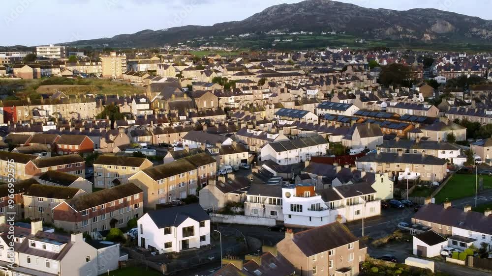 Holyhead mountain and island aerial view over sunlit homes and coastal community townhouse property Holyhead mountain and island aerial view over sunlit homes and coastal community townhouse property