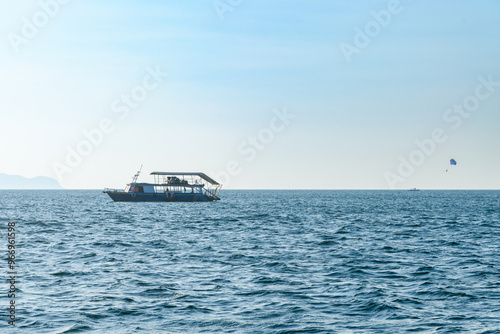 Landscape of a Boat floating in the blue sea with beautiful waves in the evening on the background of clear sky and island. at Koh Larn island. Panorama ocean. Pattaya, Thailand, ship, Vacation.