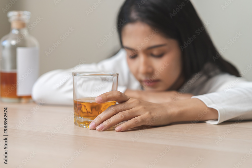 Alcoholism drunk, sad asian young woman fell asleep hand holding glass of alcohol or whiskey, alone depressed alone female drink booze. Treatment of alcohol addiction, suffer abuse problem alcoholism. Alcoholism drunk, sad asian young woman fell asleep hand holding glass of alcohol or whiskey, alone depressed alone female drink booze. Treatment of alcohol addiction, suffer abuse problem alcoholism.