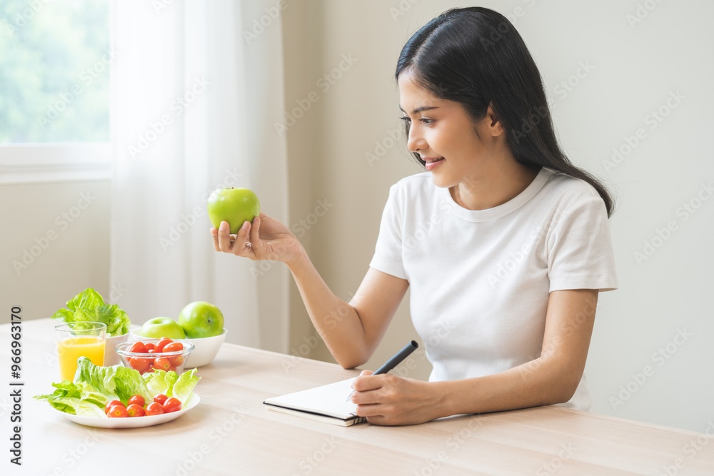 Diet, happy asian young woman working, write diet plan right nutrition holding green apple with eat fresh vegetable salad is food for good health. Nutritionist for weight loss of healthy at home. Diet, happy asian young woman working, write diet plan right nutrition holding green apple with eat fresh vegetable salad is food for good health. Nutritionist for weight loss of healthy at home.