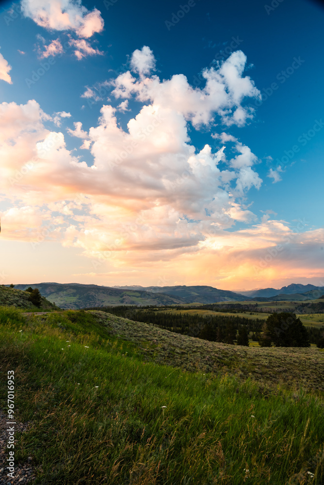 Vivid clouds float above hills at sunset in Yellowstone National Park. Vivid clouds float above hills at sunset in Yellowstone National Park.