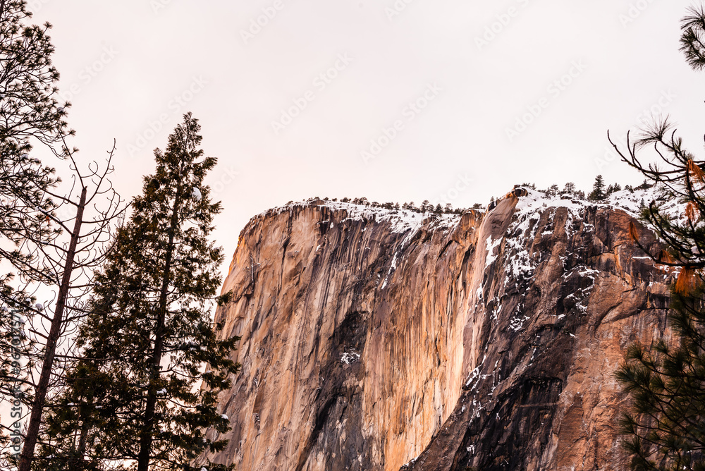 El Capitan cliff dusted with snow at sunset in Yosemite. El Capitan cliff dusted with snow at sunset in Yosemite.