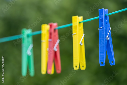 Foto Plastic Colourful clothes pegs on a washing line
