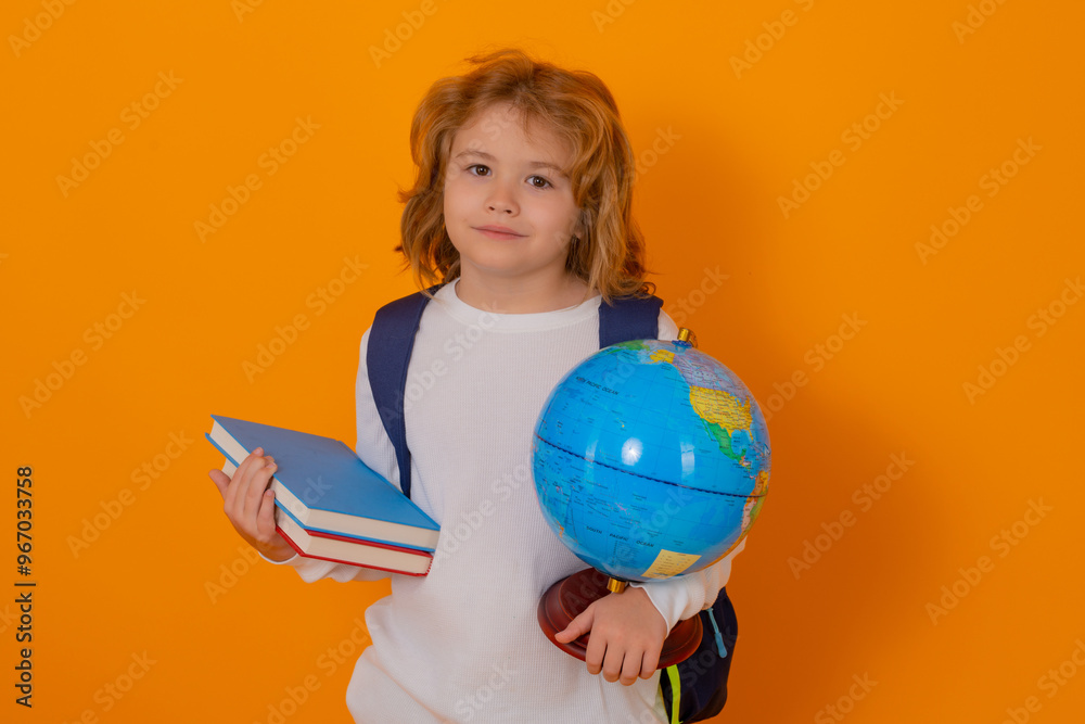 Knowledge day. School child with world globe and book. Portrait of school boy isolated on yellow studio background. Child from elementary school. Kid study and learning. Knowledge day. School child with world globe and book. Portrait of school boy isolated on yellow studio background. Child from elementary school. Kid study and learning.
