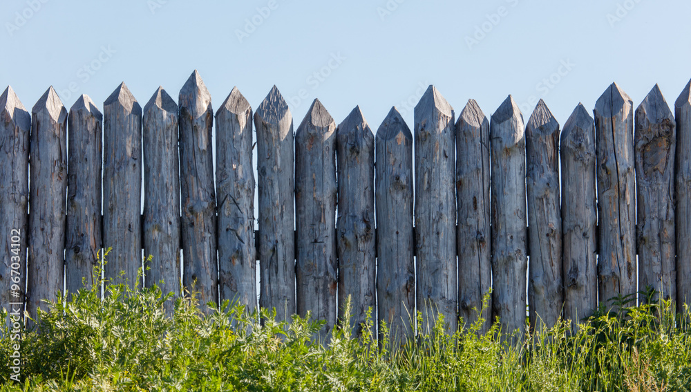 Obraz premium Wooden log fence against the sky
