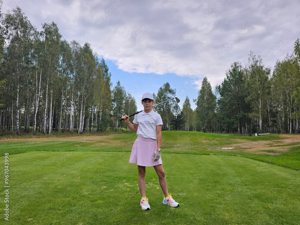 Teenager child practicing golf swing on a lush green course Teenager child practicing golf swing on a lush green course