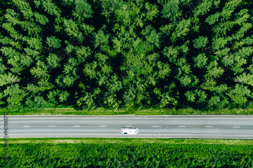 Aerial view of Caravan trailer or Camper rv on the road and green woods in summer Finland.
