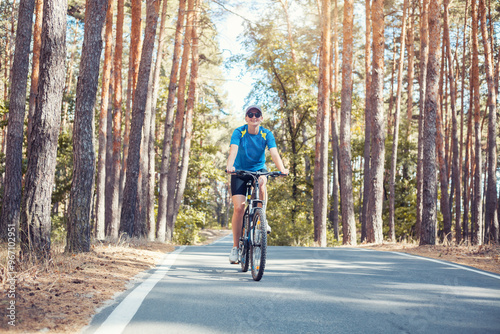 woman cyclist rides in the forest on a bike.