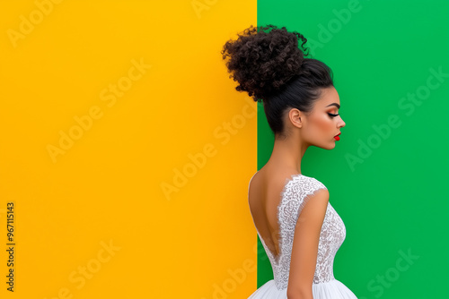 A woman with a red lip stands in front of a yellow and green wall. She is wearing a white dress and her hair is in a bun photo