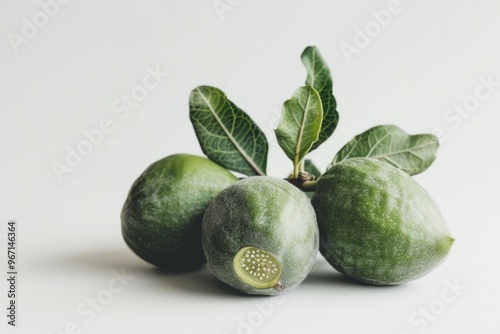 Fototapeta Naklejka Na Ścianę i Meble -  Fresh green fruits sit on a clean white surface