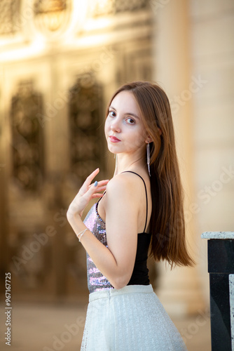 Young smiling girl walking around the city. Girl with light brown hair in summer clothes posing against the background of ancient historical buildings of Venetian style.