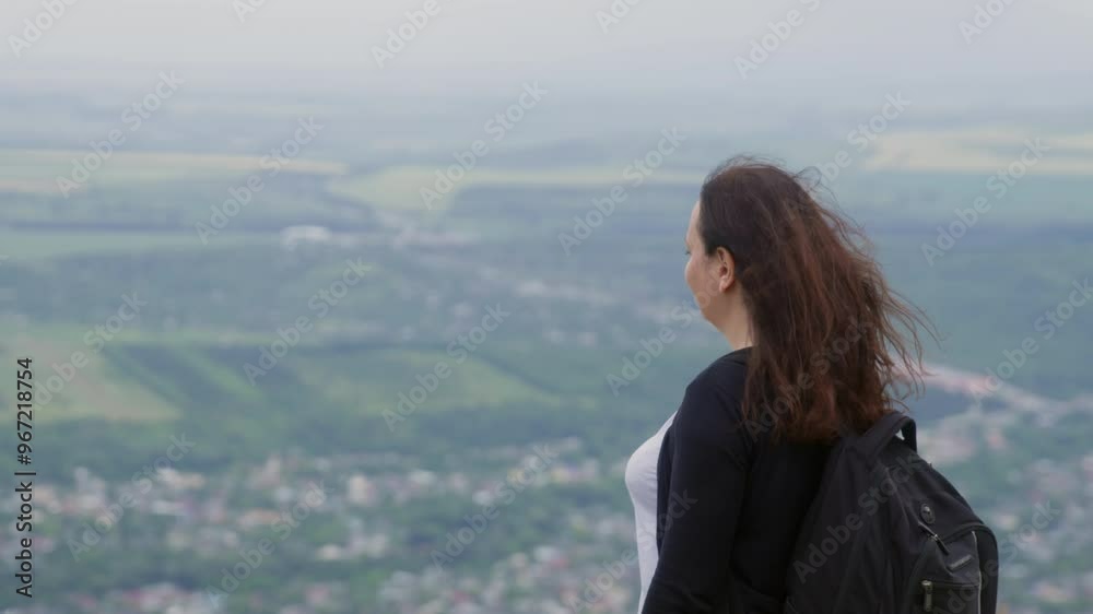 Smiling woman looking Fare Way stands on top of hills Mountain Landscape valley at Background. Woman Backpacker hiking mountain windy day. Smiling woman looking Fare Way stands on top of hills Mountain Landscape valley at Background. Woman Backpacker hiking mountain windy day.