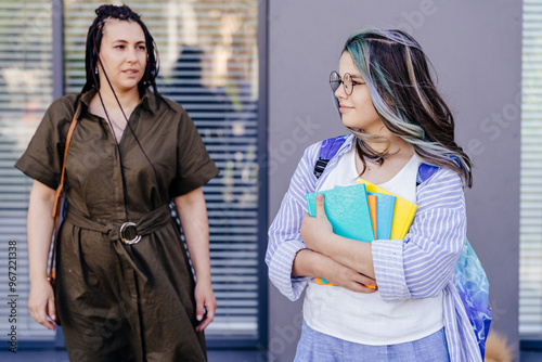 Foto Mature mother sending teener daughter to school outdoor