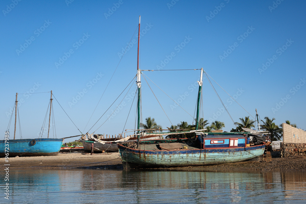 Traditional fishing boats moored by the river in Morondava, Madagascar during a clear sunny day Traditional fishing boats moored by the river in Morondava, Madagascar during a clear sunny day