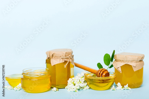 robinia honey bollte with acacia blossoms on colored table photo