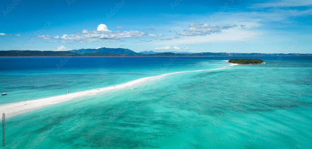 Aerial view of Nosy Iranja Island showcasing its stunning beaches, turquoise waters, and vibrant coral reefs in Madagascar's tropical paradise