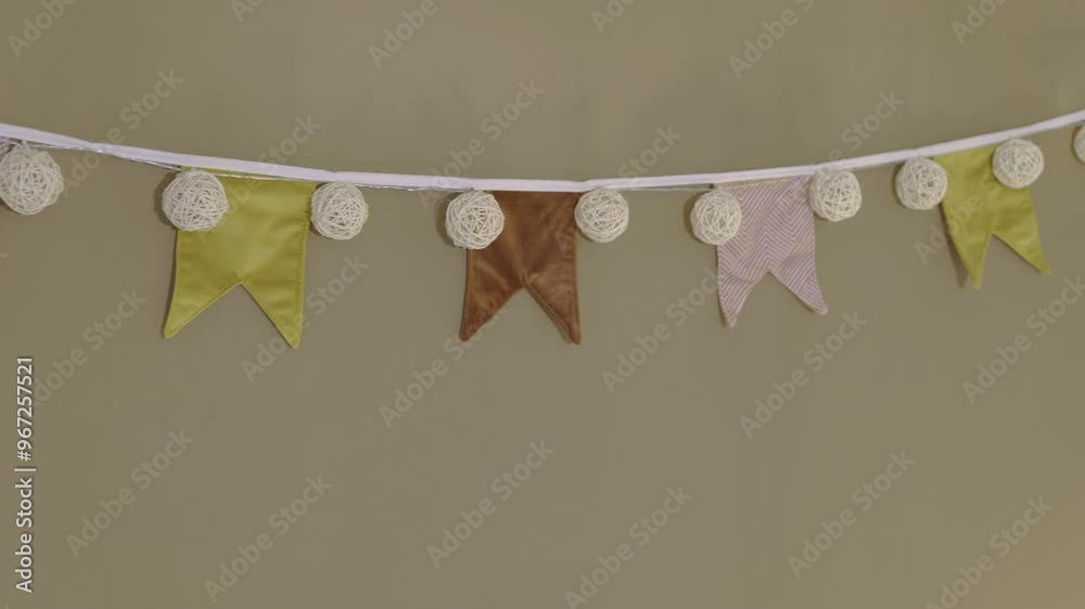 Little colored tissu pennant on a brown wall
