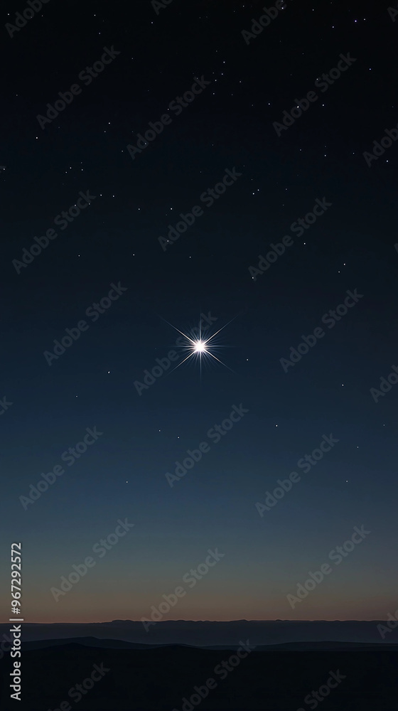 A bright star is shining in the night sky. The sky is dark and the stars are scattered all over