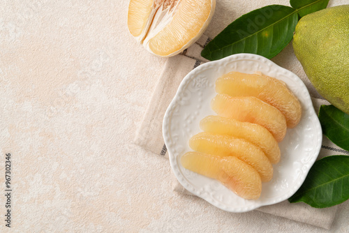 Fresh pomelo fruit with leaf on white table background.