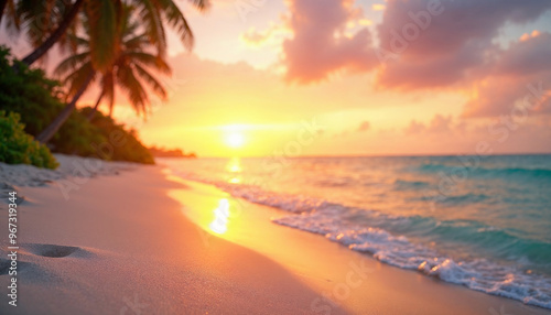 Tropical beach at sunset with sparkling ocean, light sand, and a blurred horizon.