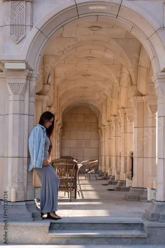 Woman Stone Archway Building - A woman stands near the entrance of a building with a stone archway.