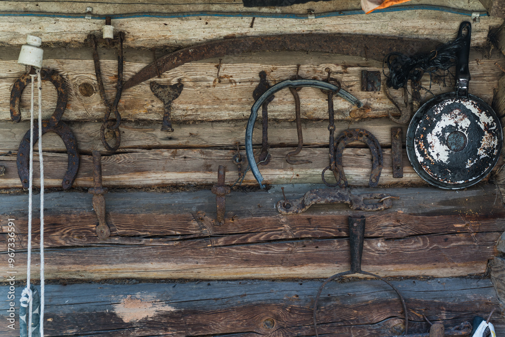 Old Slavic tools and tools hang on the wall of a log house