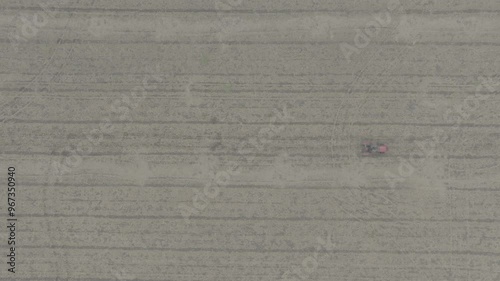 Wallpaper Mural D-log aerial drone top down shot bird eye view of red tractor driving in open dry land in reverse speed. horizontal lines on ground Torontodigital.ca