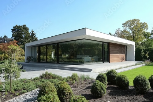 Modern house with large glass windows and landscaped garden.