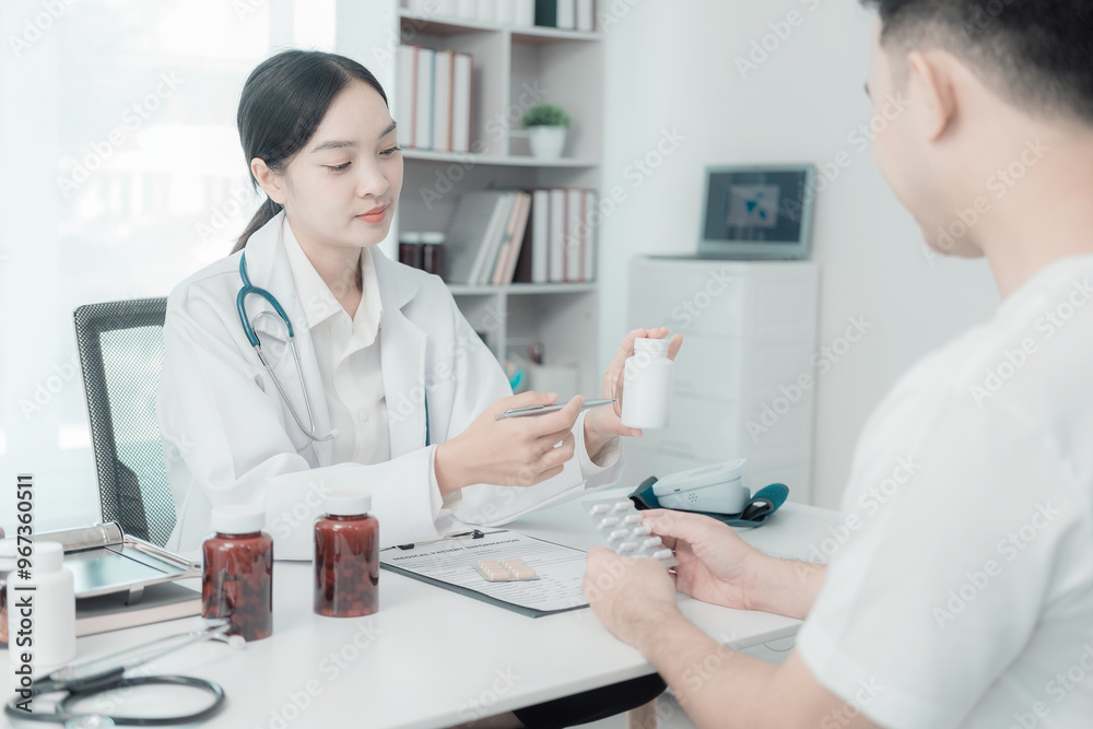 Asian female doctor and male patient discuss treatment with successful professional physician wearing white lab coat and stethoscope about injury Asian female doctor and male patient discuss treatment with successful professional physician wearing white lab coat and stethoscope about injury